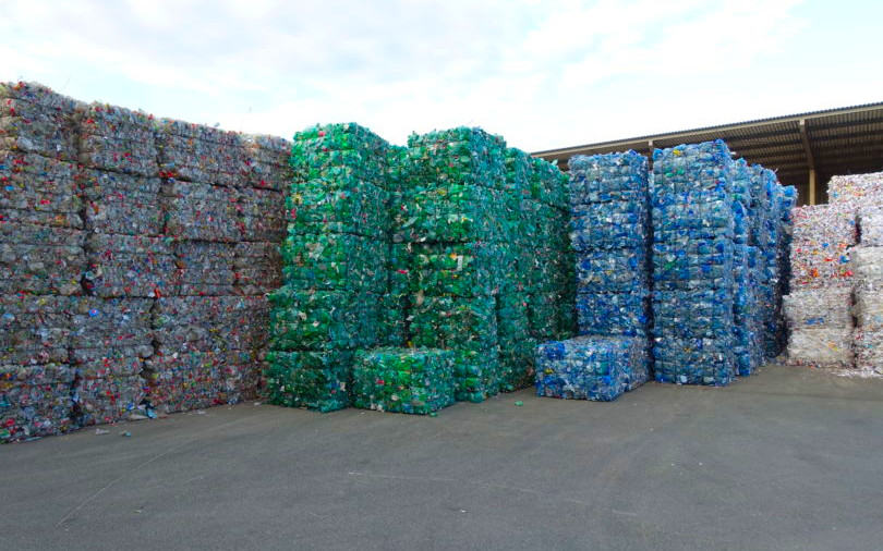 Tightly packed bales of sorted plastic waste stacked in an industrial recycling yard